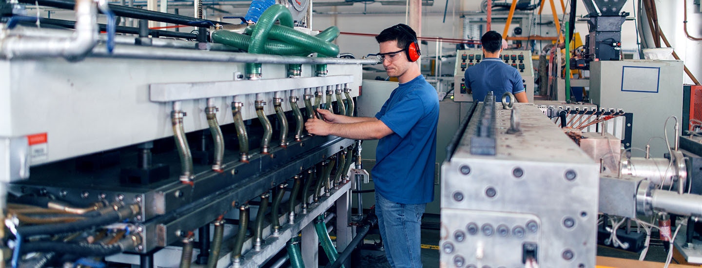 Manufacturing ERP software Manufacturing facility worker operating machinery using ERP software